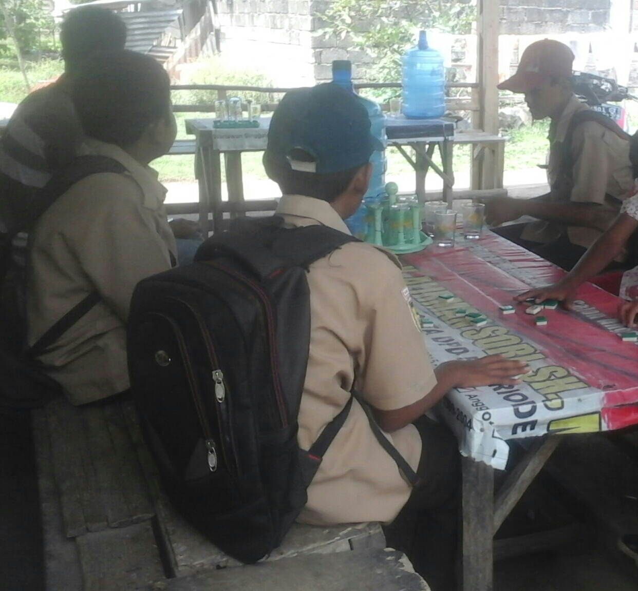 Beberapa Siswa dengan Pakaian Seragam SMP Asyik Nongkron dan Main Domino di Warung Dekat SMPN 4 Sutera