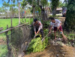 Semangat Gotong Royong, Bhabinkamtibmas Turun Tangan Bersihkan Selokan Pasca-Banjir 